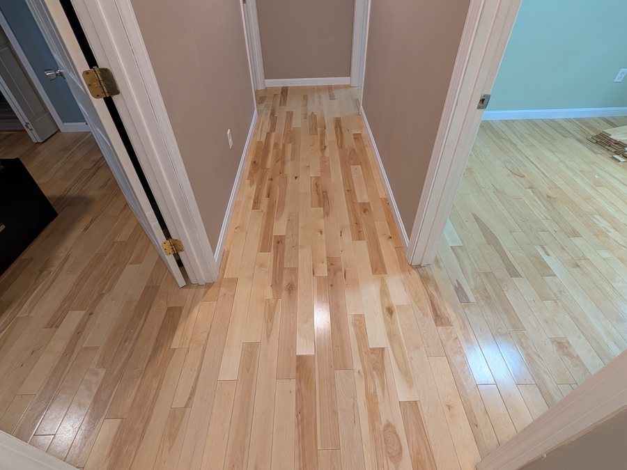 Finished yellow birch hallway running unbroken into the adjoining rooms