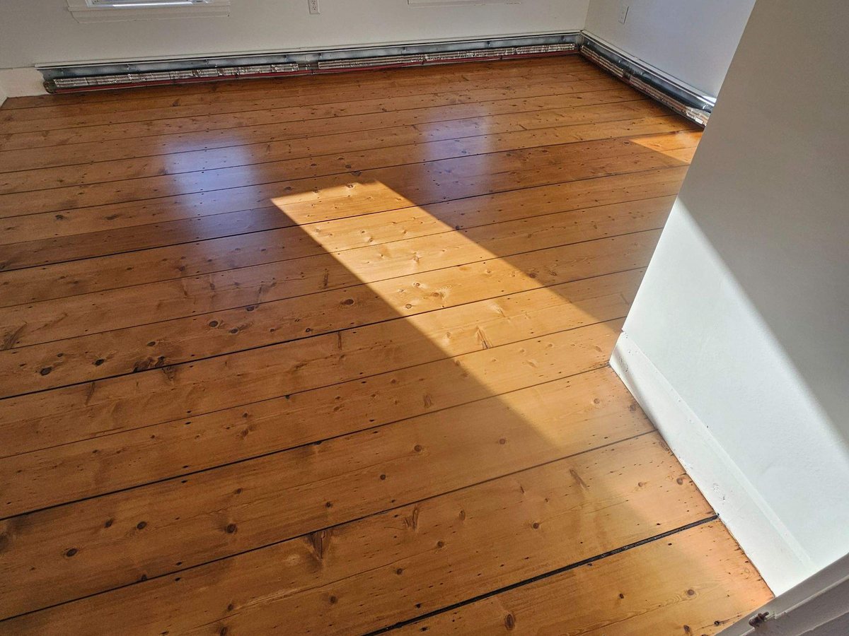 Antique hemlock plank floor restored and finished, winter light across the boards