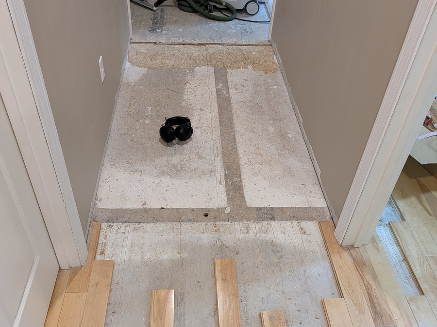 New yellow birch boards woven into an existing hallway floor